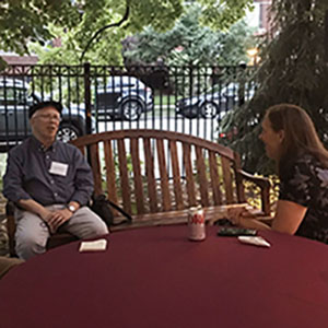 Two faculty members talking on patio